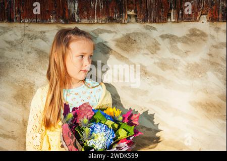 Außenporträt eines niedlichen kleinen Mädchens mit wunderschönem Blumenstrauß im Herbst Stockfoto