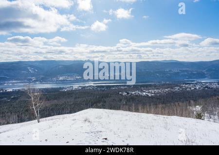 Ungefrorener Fluss Yenisei in Sibirien, friert im Winter nicht ein. Zwei hügelige Ufer eines großen Flusses. Outdoor natürliche Landschaft blauer Himmel mit Wolken, sonnig Stockfoto