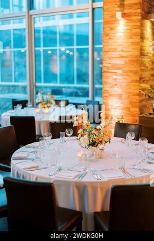 Legen Sie einen festlichen Tisch mit einem Blumenstrauß in einem Restaurant Stockfoto