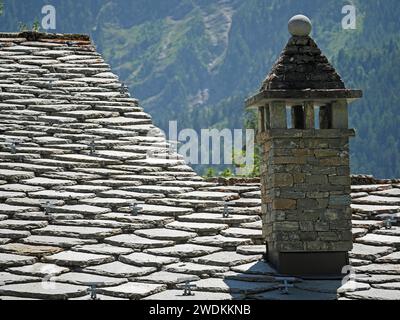 Typische Dachstruktur des Hauses in Courmayeur, Norditalien mit Steinbau aus Schornstein Stockfoto