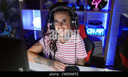Junge schöne hispanische Frau streamer spielen Videospiel mit Computer im Spielzimmer Stockfoto