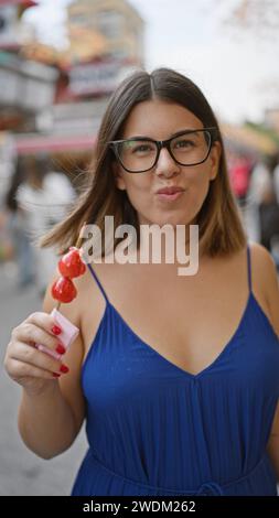 Die atemberaubende hispanische Frau serviert leckere japanische Erdbeerbonbons in der nakamise Street, einem berühmten Ort in tokio Stockfoto