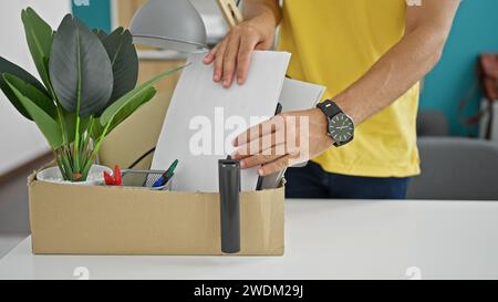 Ein junger hispano-Mann, der gefeuert wird und Dokumente auf der Verpackung von Dokumenten im Büro ablegt Stockfoto