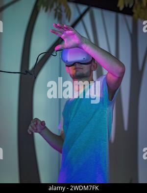 Zwei junge Männer, Besucher des Naturkundemuseums, die neue Technologien in der Ausstellung einsetzen und Virtual-Reality-Headsets platzieren. Stockfoto