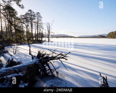 Schnee liegt auf Eis auf einem gefrorenen Loch Mallachie in den Cairngorms, Schottland, Großbritannien Stockfoto