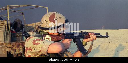 4. März 1991 Ein Koalitionssoldat feuert ein irakisches Kalaschnikow-Gewehr AK-47 auf dem Weg nach um Qasr in Kuwait in die Wüste. Stockfoto