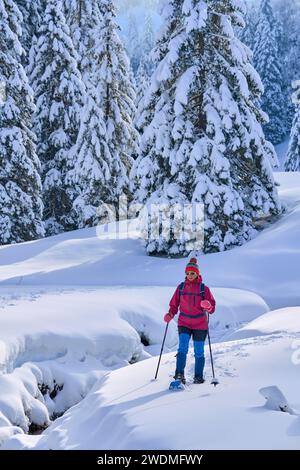 Schöne und aktive Seniorenwanderin mit Schneeschuhen im Tiefschnee im Hochhaedrich-Gebiet des Bregenzer Waldes in Vorarlberg, Österreich Stockfoto