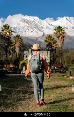 Touristenwanderungen durch die Stadt Yungay mit dem schneebedeckten Huascaran im Hintergrund. Stockfoto