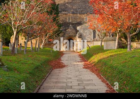 Pfad zwischen dem erhöhten Friedhof in Richtung einer Kirchentür im Herbst - Faringdon, Oxfordshire, England Stockfoto