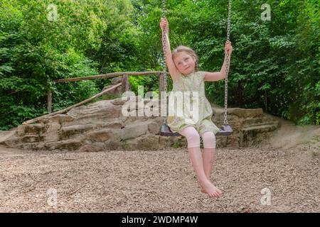 Ein fünfjähriges Mädchen auf einer Schaukel Stockfoto