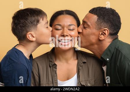 Liebe schwarze Vater und Sohn, die glückliche junge Frau küssen Stockfoto