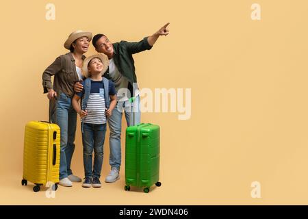 Glückliche, liebende schwarze Familientouristen, die zusammen reisen und auf einen Kopierraum zeigen Stockfoto