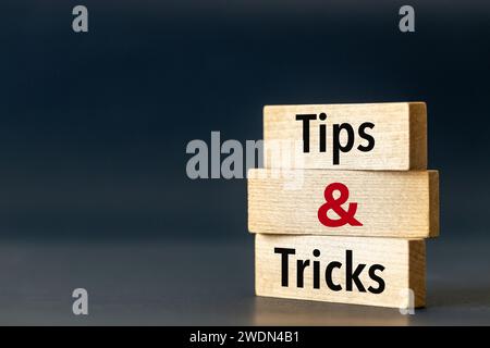 Holzblöcke mit den Worten Tipps und Tricks. Symbol für Tipps und Tricks. Schöner blauer marineblauer Hintergrund. Geschäftskonzept und Unternehmensberatung. Spa kopieren Stockfoto