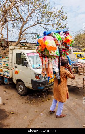 Lokaler Lebensstil: Ein einheimischer Mann, der auf der Straße spaziert (Strand Bank Road) und Spielzeug in Kalkutta, Westbengalen, Indien verkauft Stockfoto