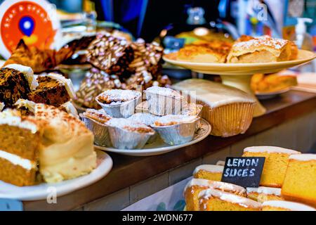 In einer lokalen Bäckerei werden verschiedene frisch gebackene Produkte präsentiert, mit Schwerpunkt auf Muffins und Zitronenscheiben. Stockfoto