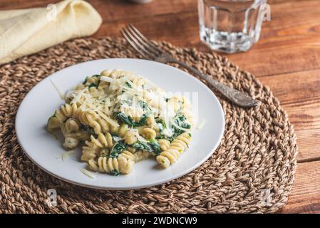 Cremige Pasta mit Spinat und Thymian auf weißem Teller Stockfoto