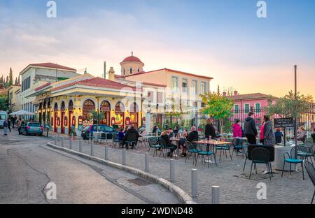 Leute im Straßencafé in Plaka, neben der römischen Agora, mit alten und neoklassizistischen Gebäuden. Athen, Griechenland. Stockfoto