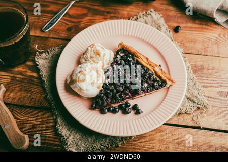 Portion frisch gebackener Galette mit Schattenbeeren und zwei Schaufeln Vanilleeis Stockfoto