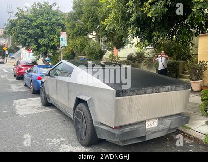 San Francisco, Usa. Januar 2024. Ein Hundeführer hält an, um ein Foto von einem Tesla Cybertruck zu machen, der am Sonntag, den 21. Januar 2024 in San Francisco geparkt hat. Das Modell wird jetzt häufiger angezeigt. Foto: Terry Schmitt/UPI Credit: UPI/Alamy Live News Stockfoto