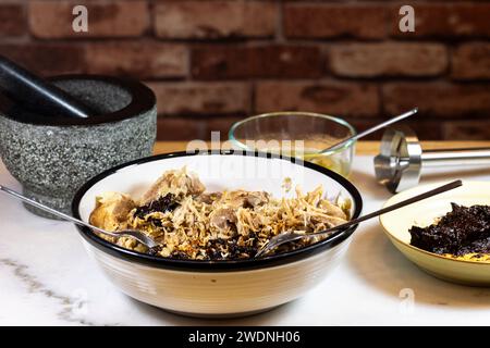 Kochen und Verarbeiten von Pulled Schweinefleisch mit roter Anchochili-Paste und Schweinefleisch auf einem Schneidebrett aus weißem Marmor Stockfoto