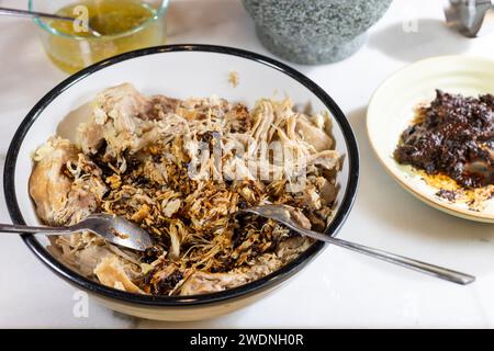 Kochen und Verarbeiten von Pulled Schweinefleisch mit roter Anchochili-Paste und Schweinefleisch auf einem Schneidebrett aus weißem Marmor Stockfoto