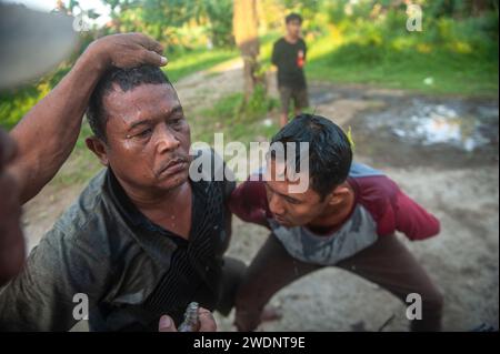 Medan, Indonesien. Januar 2024. Einheimische javanische Männer spielen als trauernde Soldaten und tanzen bei der Jaran Kepang Kulturkunstausstellung im Bezirk Medan Polonia, Stadt Medan, Provinz Nord-Sumatra, Indonesien, am 21. Januar, zu Gamelan-Musik. 2024. Jaran Kepang ist eine Fusion aus musikalischer Tanzkunst und transzendentaler Kommunikation, die typisch für den javanischen Stamm ist und bis heute erhalten bleibt, sagt Supringadi, 30, Leiter des Gemeindeverbandes Jaran Kepang im Unterbezirk Karang Sari. (Foto: Sutanta Aditya/NurPhoto) Credit: NurPhoto SRL/Alamy Live News Stockfoto