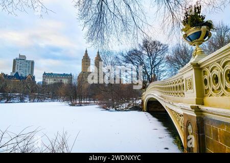 Panoramablick auf den New York Central Park, den Eissee der Bow Bridge und die Gebäude der Upper West Side im Winter Stockfoto