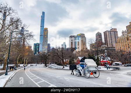 Vintage-Winterblick auf die Gebäude im Stadtbild von Manhattan vom Central Park aus mit einer Pferdekutsche in New York Stockfoto