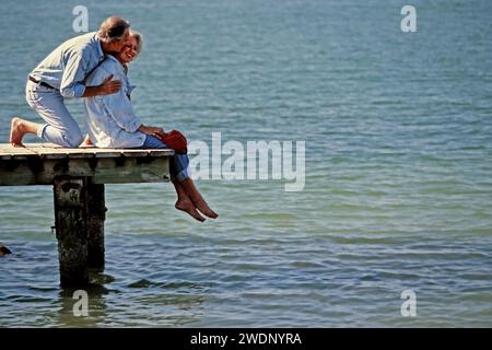 Ein älteres Paar, das einen romantischen Moment auf dem Dock mit Blick auf den Atlantik in Südflorida im Urlaub hat Stockfoto