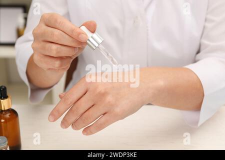 Dermatologe testet kosmetisches Produkt am weißen Tisch, Nahaufnahme Stockfoto