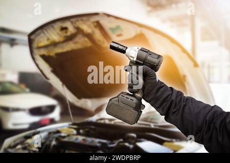 Kfz-Mechaniker Hand-Schlagschrauber Akku in der Autoreparaturgarage , Kfz-Wartungsservice-Konzept Stockfoto