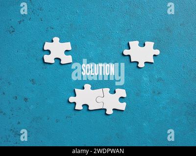Die Wortlösung mit Puzzleteilen auf blauem Hintergrund. Problemlösungs- und Kooperationskonzept. Stockfoto
