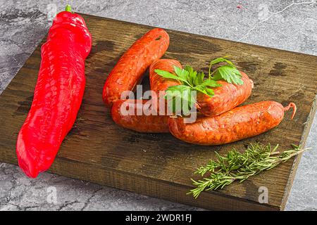 Eine Großaufnahme von gekochter Wurst auf Schneidebrett mit Kräutern Stockfoto