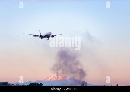 VANCOUVER, BC, KANADA - 27. JULI 2023: Boeing 777 mit Feuer in der Nähe von YVR in Richmond, BC, mit Mount Baker im Hintergrund, schwarzer Rauch, schwelend Stockfoto