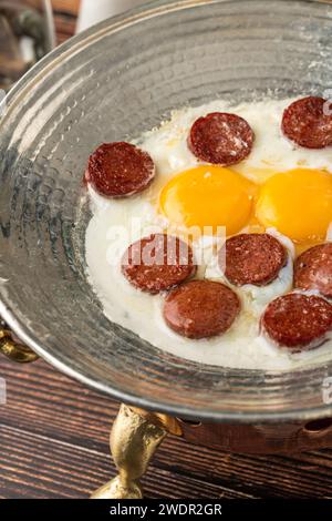 Spiegeleier mit türkischer Wurst mit Brot und Tee auf Holztisch Stockfoto
