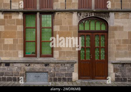 Verzierte Holztür und Fenster in einem Steingebäude in Belgien Stockfoto