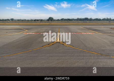 Gabelschilder, Abfahrt von der Start- und Landebahn zu den Rollbahnen am Flughafen. Gelbe Markierungen für Flugzeugbewegungen mit Parknummern auf dem Vorfeld. Stockfoto