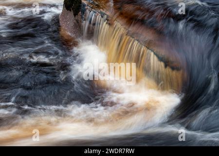 Schnell fließendes Wasser über Felsen. River Findhorn, Morayshire, Schottland. Langzeitbelichtung abstrakt Stockfoto