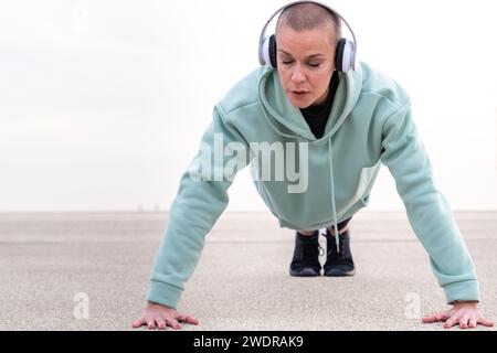 Aktive und fitte Sportlerin, die im Freien Liegestütze macht. Stockfoto
