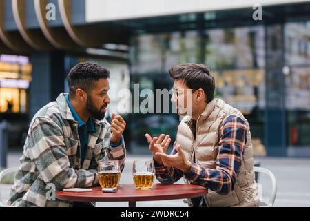 Die besten Freunde haben in der Stadt Bier getrunken und in der Bar geredet. Begriff der männlichen Freundschaft, Bromanz. Stockfoto