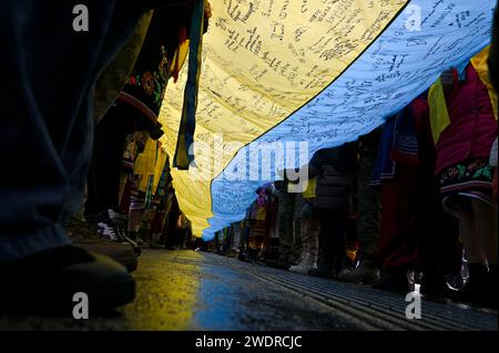 LVIV, UKRAINE – 21. JANUAR, 2024 - die Menschen werden während der Bewerbung, den Rekord der Ukraine für die längste ukrainische Flagge mit den Wünschen des Militärs und der Kinder in der ganzen Ukraine und an der Front vor dem Akademischen Opern- und Balletttheater Solomija Krushelnytska Lemberg, Lwiw, Westukraine, aufgenommen. Die Veranstaltung fand im Vorfeld des Tages der Einheit der Ukraine und des 105. Jahrestages der Unterzeichnung des Einigungsgesetzes statt, eines Abkommens, das die ukrainische Volksrepublik und die westukrainische Volksrepublik am 22. Januar 1919 unterzeichnet haben. Stockfoto