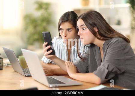 Verwirrte Tele-Mitarbeiter sehen zu Hause fantastische Telefoninhalte Stockfoto