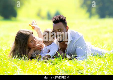 Gemischte rassistische Eltern und birassisches Baby-Outdoor-Porträt. Multirassische Familie. Internationale Familie Mutter und Vater mit zweirassigem Kind. Birassische Familie Stockfoto