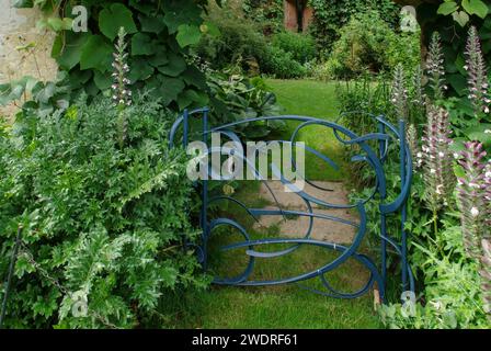 Sudeley Castle and Gardens, Winchcombe, Gloucestershire, Großbritannien; stilvolles blaues Metalltor, das zu einem versteckten Garten führt Stockfoto