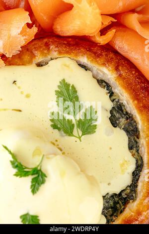 Spinatbrötchen mit Käsesoße und Lachs daneben auf einem Teller Stockfoto