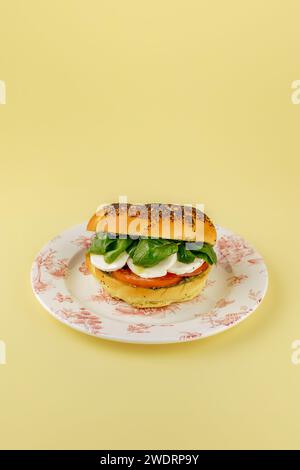 Bagel mit Tomaten, Mozzarella, Spinat und Pesto-Sauce Stockfoto