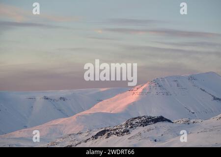 Majestätischer schneebedeckter Berggrat, der bei Sonnenuntergang glüht Stockfoto