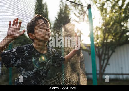 Junge, um verschiedene lustige Gesichter auf dem Trampolin zu machen Stockfoto