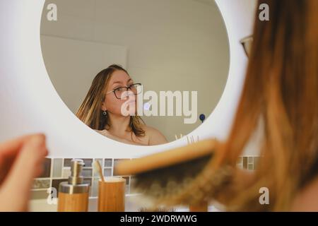 Europäische Frau leidet unter Haarausfall. Schneidet sich zu Hause selbst die Haare Stockfoto