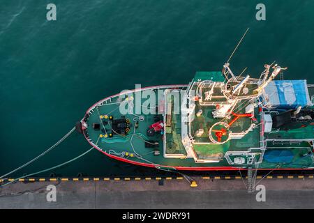 Von oben nach unten auf das im Hafen verankerte Fischerboot. Ein kleines Fischtrawler-Schiff liegt am Pier Stockfoto